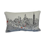 A cream-colored throw pillow with an embroidered city skyline scene, including Lake Michigan and the John Hancock Building.
