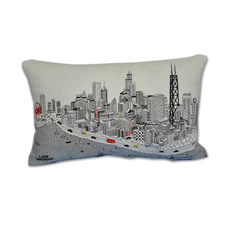 A cream-colored throw pillow with an embroidered city skyline scene, including Lake Michigan and the John Hancock Building.