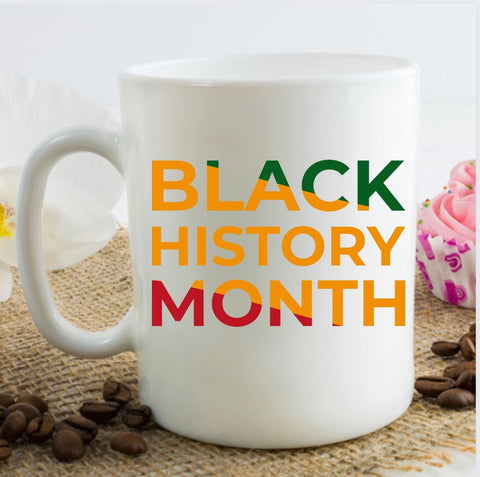 A white mug with Black History Month text in red, yellow, and green.