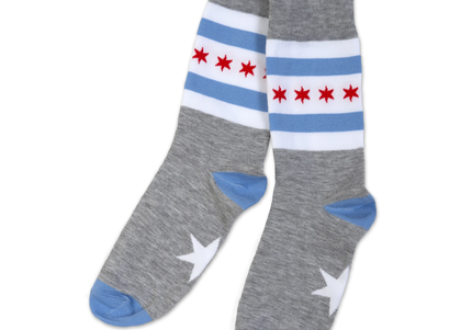 A pair of grey socks with the Chicago flag design elements of blue and red stripes and a star shape on the sole.