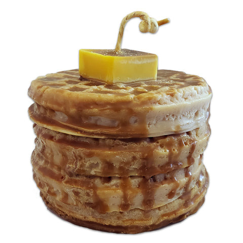 A candle designed to resemble a stack of waffles with butter and syrup on top, made from natural soy wax.